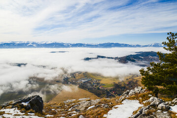View from Cerenova skala (rock) in West Tatras  in Liptov. Near Liptovsky Mikulas city in foggy weather. Spring time, cloudy weather, Slovakia. Green forest. Village in the fog.
