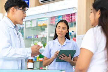 Fototapeta na wymiar Medical pharmacy and healthcare providers concept. Professional Asian man and woman pharmacist recommend and selling medical product, medicine, drugs and supplements to patient customer in drugstore.