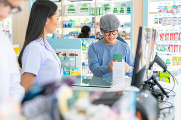 Obraz premium Medical pharmacy and healthcare providers concept. Professional Asian woman pharmacist recommend and selling medical product, medicine, drugs and supplements to male patient customer in drugstore.
