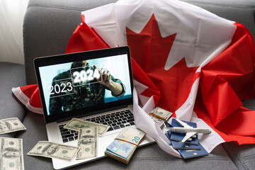 laptop with plane, money and canada flag
