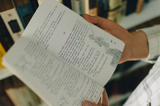 Lviv, Ukraine - April 7, 2023: A girl reading a famous classic novel by Antoine de Saint-Exupéry, "The Little Prince"