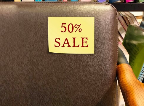 Promotion tag stick on sofa with text 50% SALE, to inform customers a sale of goods at big discount 50% prices to get rid of stock,  a half-price sale store promotion