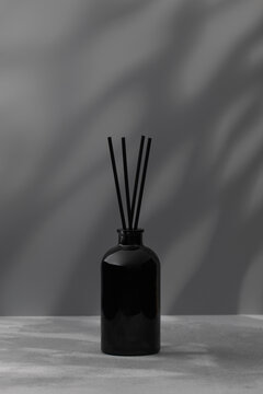 Bamboo sticks in a black bottle with indoor perfumes. Glass diffuser with fragrance for home.