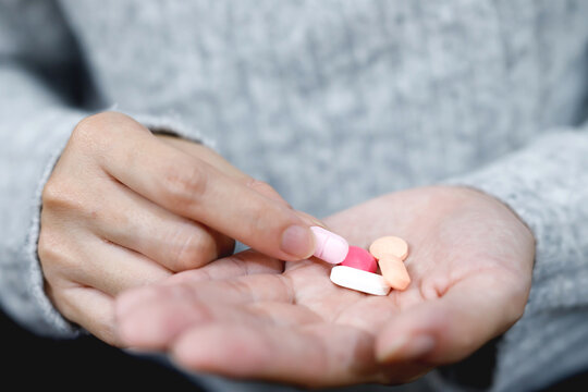 Close Up Hand Woman Holding Taking Multiple Pills. Stop Drug Use Taking Medication Health Care Medical Concept.