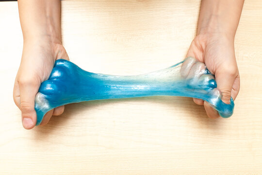 Woman playing with blue slime isolated on white, closeup. Antistress toy.