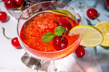 Cherry and lime alcoholic booze cocktail, sweet summer alcohol drink with cherry juice, vodka and fruit lime cherry garnish