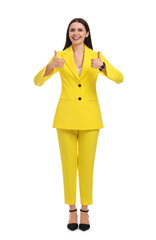 Beautiful happy businesswoman in yellow suit showing thumbs up on white background