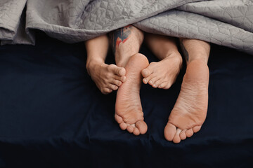 Passionate couple having sex on bed, closeup of legs