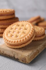 Tasty sandwich cookies with cream on light grey table, closeup