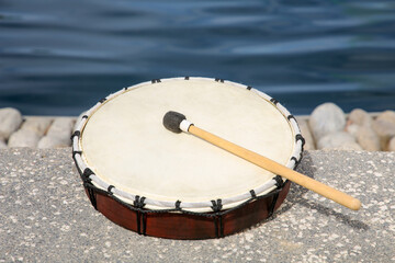 Drum and drumstick near sea. Percussion musical instrument