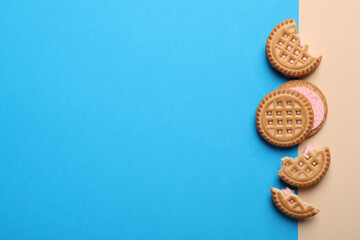 Obraz na płótnie Canvas Tasty sandwich cookies with cream on color background, flat lay. Space for text