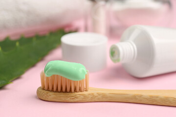 Fototapeta na wymiar Toothbrush with aloe toothpaste on pink background, closeup