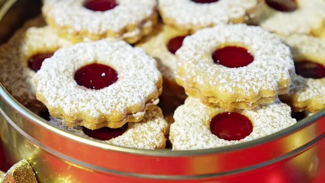 selbstgebackene Spitzbuben Pl&auml;tzchen f&uuml;r Weihnachten mit Puderzucker in einer Dose Close Up