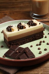 Tasty mousse cake and chocolate on table