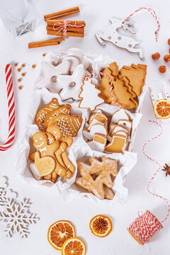 Top view of unpacked christmas present with sweets on a white textured surface, close-up. Christmas celebration concept