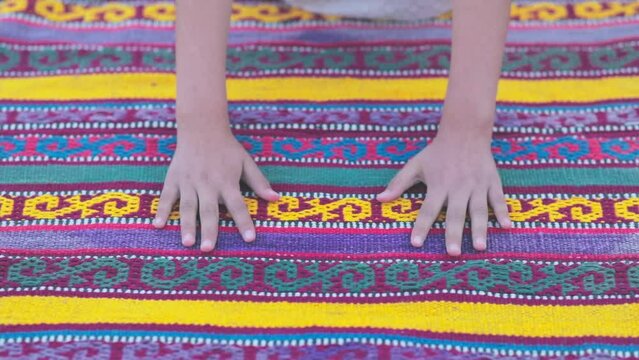 Hands of an young woman stroking a handmade carpet