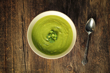 Broccoli soup with spoon on a wooden background - 608676453