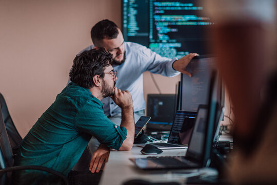 Programmers engrossed in deep collaboration, diligently working together to solve complex problems and develop innovative mobile applications with seamless functionality.