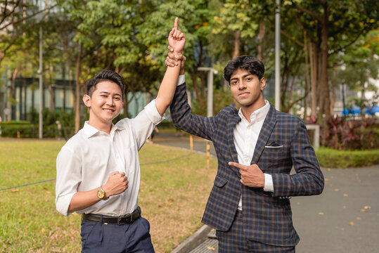 An indian guy champions and endorses his fellow office mate or teammate. A young man vouched by his colleague and supporter.