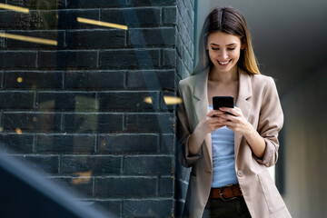 Portrait of successful woman with mobile in urban background. Business technology device concept