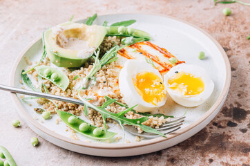 Healthy diet breakfast with grilled halloumi cheese, quinoa, egg and avocado