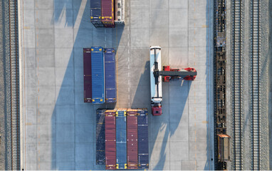 Aerial top down view crane loading container from container truck to container train, Cargo train...