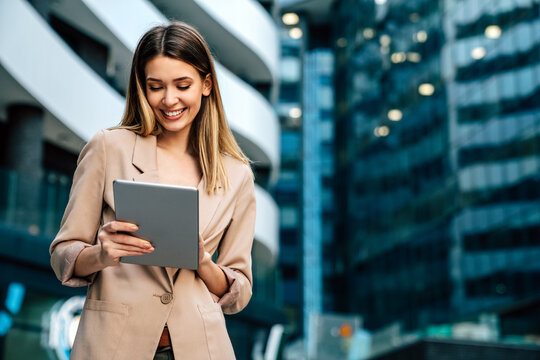 Portrait of successful woman using digital tablet in urban background. Business people concept