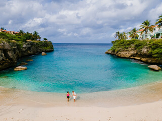 A couple of men and women in swimshorts and bikinis at Playa Lagun Beach Cliff Curacao, 