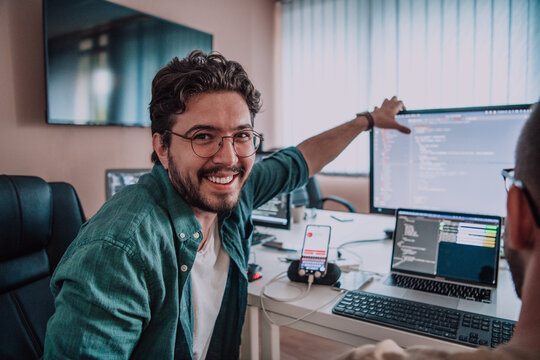 Programmers engrossed in deep collaboration, diligently working together to solve complex problems and develop innovative mobile applications with seamless functionality.