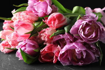 Beautiful bouquet of colorful tulip flowers on black table, closeup