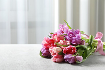 Beautiful bouquet of colorful tulip flowers on light gray table
