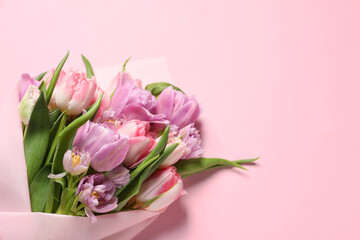 Beautiful bouquet of colorful tulip flowers on pink background, top view