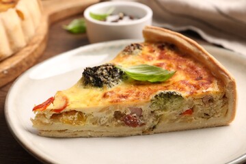 Piece of delicious homemade vegetable quiche on plate, closeup