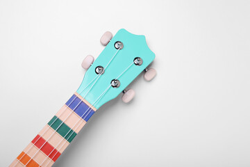 Colorful ukulele neck on white background, top view. String musical instrument