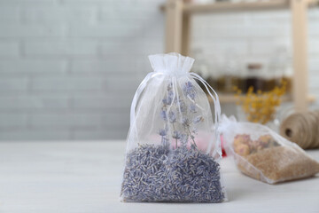 Scented sachet with dried lavender flowers on white table