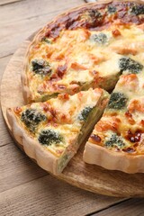 Pieces of delicious homemade quiche with salmon and broccoli on wooden table