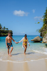 A couple of men and women in swimshorts and bikinis at Playa Lagun Beach Cliff Curacao, Lagun Beach Curacao a small island in the Caribbean. 