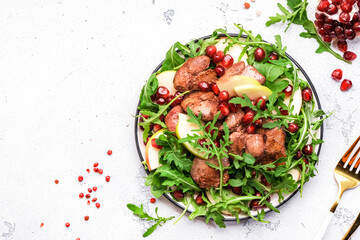 Healthy useful salad with grilled chicken liver, green apple, pomegranate seeds and fresh arugula....