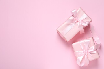 Beautiful gift boxes on pink background, flat lay. Space for text