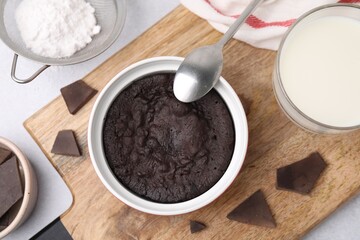 Tasty chocolate pie and ingredients on light grey table, flat lay. Microwave cake recipe