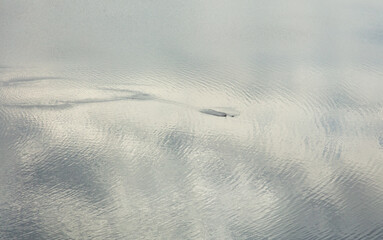 Reflection of sky and clouds on water surface. Abstract background