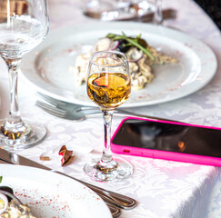 Wine served on a table in a restaurant with a mobile phone