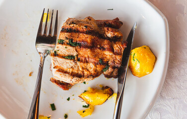 Slices of smoked meat on a plate with vegetables and greens