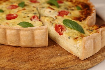 Delicious homemade cheese quiche on wooden board, closeup