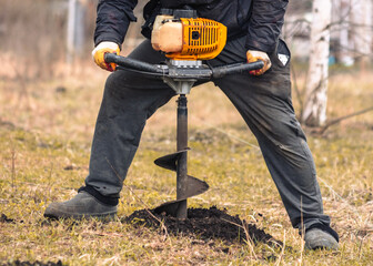 Worker digs the ground with a gasoline blower in the garden