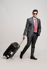 Young indian businessman with a suitcase or trolly. business tour concept