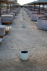 Naklejka premium Trashes on the empty beach on the summer, with sand and rest places