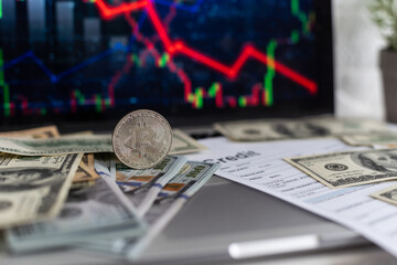 Cryptocurrency market is going down, is time to sell, red candles. The graph evolution of Bitcoin on a laptop and smartphone display showing the prices falling