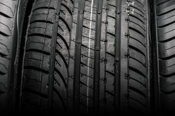 A new tire is placed on the tire storage rack in the car workshop, Tire stack background, Car tires on a dark, vehicle tyre, Tire on black bckground