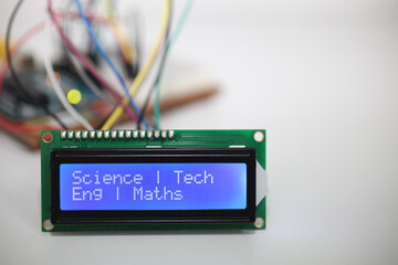 Blue LCD Display displaying the message 'Science Tech Eng Maths' with a microcontroller and...